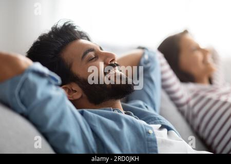 Satisfied eastern young spouses resting at home Stock Photo