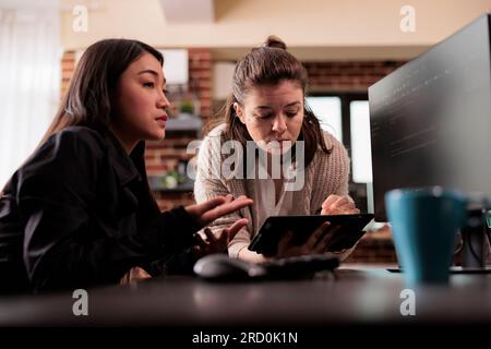 Diverse programming engineers analyzing html code on computer, planning artificial intelligence project. Web developers working on machine learning software, developing new interface. Stock Photo