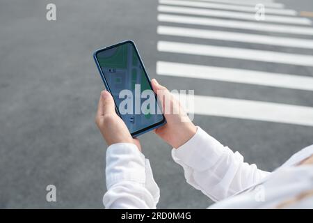 Hands of businesswoman checking taxi application on smartphone Stock Photo