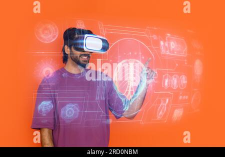 Eastern young man in casual gamer using virtual reality glasses Stock Photo