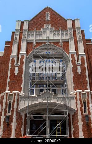 Workers stand on scaffolding to repaint fixtures around stained glass windows of the Cathedral of St. John Berchmans in Shreveport, Louisiana.  Tall s Stock Photo