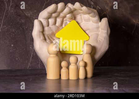 Hands with cut out paper silhouette on table. Family care concept. Stock Photo