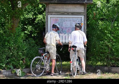 West Chicago, Illinois, USA. A pair of cyclists stop to check a map along the Illinois Prairie Path trail in west suburban Chicago. Stock Photo