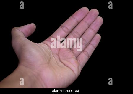 open left hand isolated on black background.One empty male palm hand holding something on black background Stock Photo