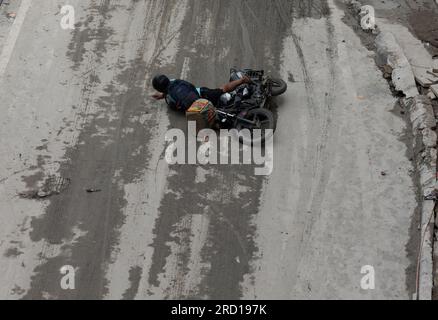 A motorcyclist falls down due to the slippery road near the Red Fort as floodwater of the swollen Yamuna River recede in New Delhi. The locals and authorities carry out a cleanliness drive in flood-affected low-lying areas to minimize the waterborne diseases. Again Yamuna water level reached 205.93 metres above danger mark of 205.33 official said. The Yamuna Rover broke a 45 years record and reached its all-time highest level of 208.65 on July 2023 after heavy rainfall and release of water from the Hathnikund barrage in Haryana. Stock Photo