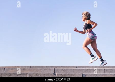 happy african american woman running outdoors Stock Photo