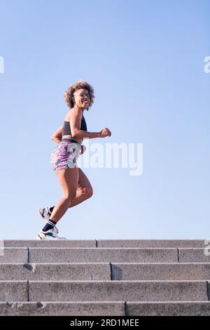 happy african american woman running outdoors Stock Photo