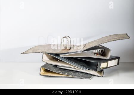 Old empty file folders or ring binders on a white office desk in an archive, concept for bureaucracy, administration and business, copy space, selecte Stock Photo