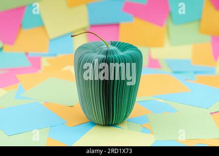 an apple made of sheets of paper with multicolored paper sticky notes on background Stock Photo