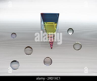Glass pyramid prism and balls with colorful light reflection on white horizontal stripe on black background Stock Photo
