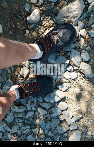 Legs of hikers in sneakers on a mountain rocky surface Stock Photo