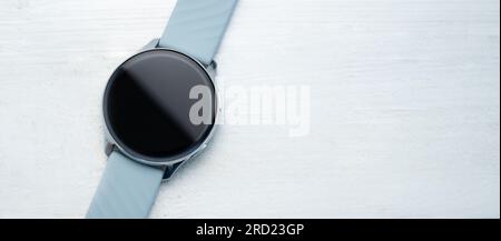 Smart watch with digital screen and copy space lying on white table background. Innovative gadget with touchscreen Stock Photo