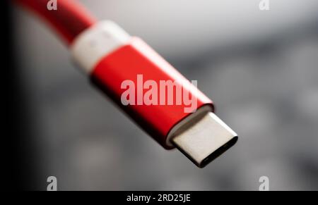 Red connector usb type C for smartphone and gadgets closeup. Plug micro cable for mobile devices in macro view Stock Photo