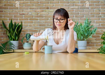 Middle aged woman drinking fermented milk product from bottle Stock Photo