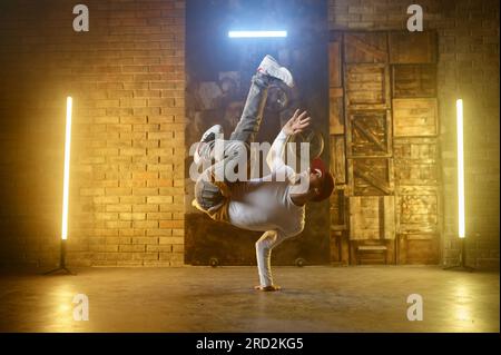 Young adult man breakdancing doing one handed handstand Stock Photo