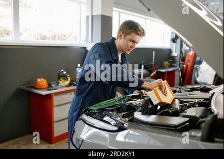 Engine air filter replacement concept, auto mechanic at work Stock Photo