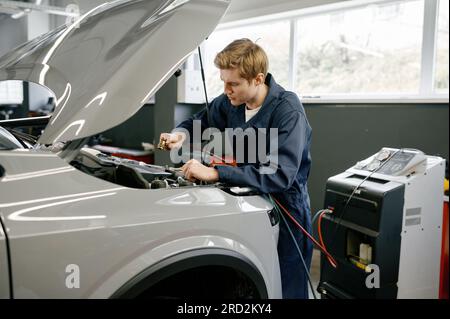 Male technician doing diagnostics of car air conditioning climate system Stock Photo