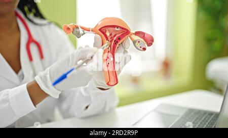 African american woman doctor holding anatomical model of uterus at clinic Stock Photo