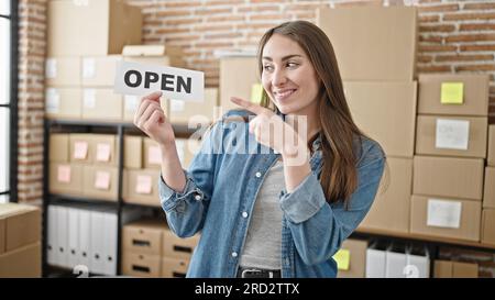 Young beautiful hispanic woman ecommerce business worker pointing with finger to open paper at office Stock Photo