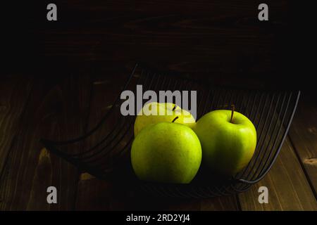 Metall bowl with green apples on dark wooden background Stock Photo