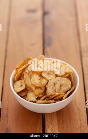 Close-up of Crunchy salty banana chips in white bowl, made fried banana,  Indian salty snacks (Namkeen), Stock Photo