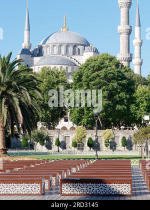 Sultan Ahmed Mosque aka Blue Mosque in Sultanahmet Park, Istanbul, Turkey. Quaint area with trees, garden and wooden benches. Stock Photo
