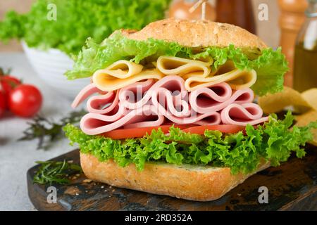 Sandwich. Tasty sandwich with ham or bacon, cheese, tomatoes, lettuce and grain bread. Delicious club sandwich or school lunch, breakfast or snack. Stock Photo