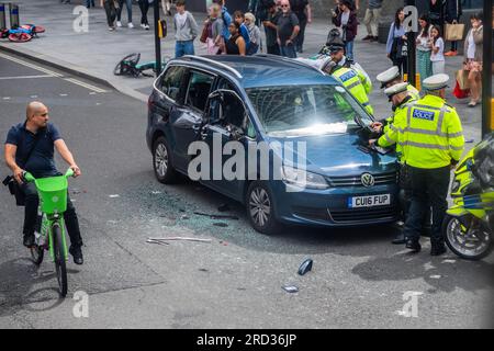 London, UK. 18th July, 2023. Motorcycle traffic police attend a private hire vehicle with side damage at the junction of Tottenham Court Road and Oxford Street. Credit: Guy Bell/Alamy Live News Stock Photo