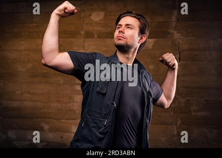 Young strong handsome man posing on wall background Stock Photo