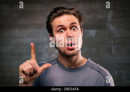 Young handsome man with idea portrait on gray wall background Stock Photo