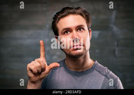 Young handsome man with idea portrait on gray wall background Stock Photo