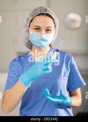 Nurse fills syringe with injection solution Stock Photo