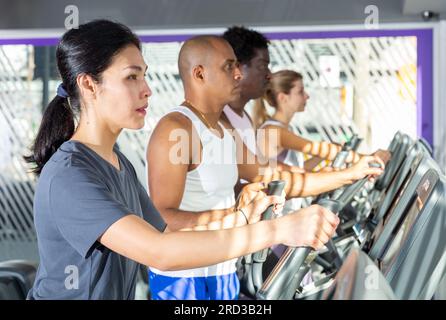 People having running elliptical trainer class in club Stock Photo