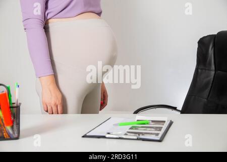 Pregnant girl with a big belly in the doctor's office. The concept of obesity and overweight during pregnancy. Complications in the third trimester. Stock Photo