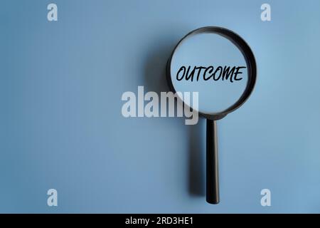 Top view image of magnifying glass on blue background with text OUTCOME. Copy space for text Stock Photo