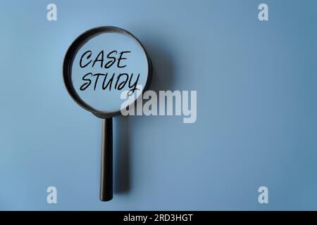 Top view image of magnifying glass on blue background with text CASE STUDY. Copy space for text Stock Photo