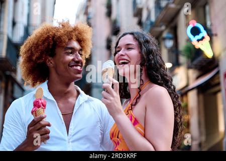 multiethnic couple dating and eating ice cream in summer Stock Photo