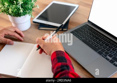 student using laptop and writing notes. Stock Photo