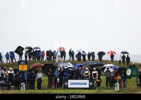 Hoylake, Merseyside, UK. 18th July 2023; Royal Liverpool Golf Club, Hoylake, Merseyside, England: The Open Championship Practice Day; spectators attar tee of the 7th hole shelter from the rain under umbrellas Credit: Action Plus Sports Images/Alamy Live News Credit: Action Plus Sports Images/Alamy Live News Stock Photo