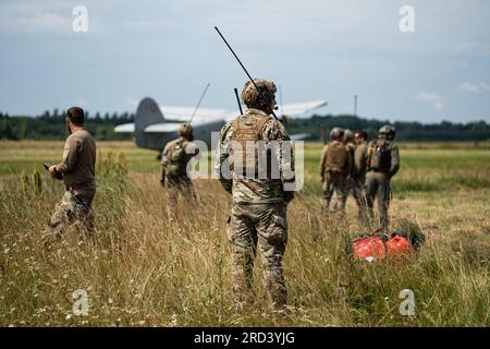 Members of the Lithuanian Special Operations Forces, Latvian Special Operations Forces, and U.S. Air Force Combat Controllers assigned to the 352d Special Operations Wing control a landing aircraft during special operations air-land integration training near Daugavpils, Latvia, June 28, 2023. Operational readiness is paramount to partnerships, crisis response, deterrence and support to Allies and partners. Today’s global environment requires the ability to rapidly deploy and sustain operations from great distances. Through collaborative efforts with our Allies and Partners, the U.S. works to p Stock Photo