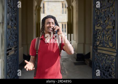 Male Student Making Call On Mobile Phone Outside University Building In Oxford UK Stock Photo