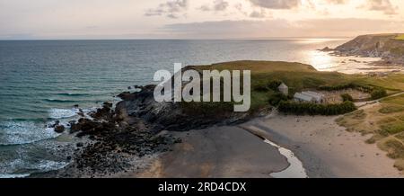 Aerial landscape panorama view of Church Cove with it's historic church and Dollar Cove at Gunwalloe in Cornwall at sunset Stock Photo