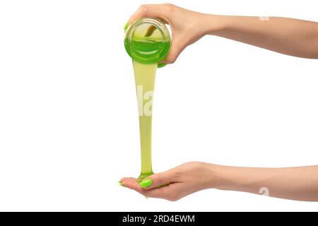 Green slime toy in woman hand with green nails isolated on a white background. Stock Photo