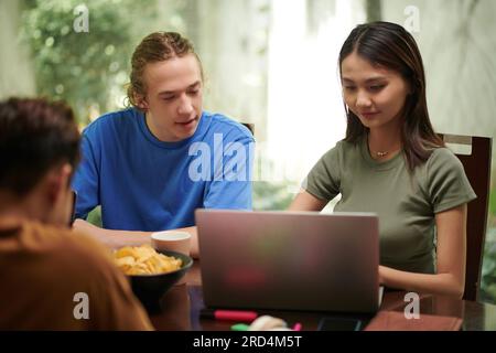 College students gathered at homw to work on project together Stock Photo