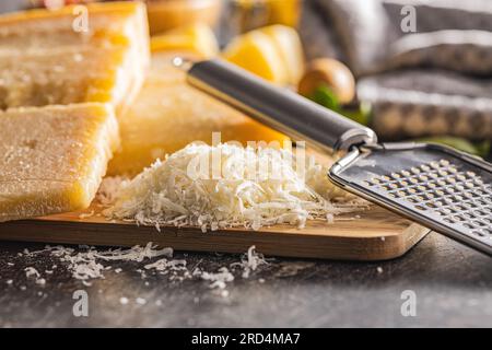 Grated parmesan cheese on the cutting board. Stock Photo