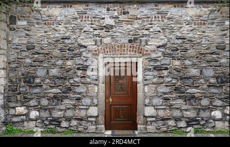 Old stone wall surrounding a garden Stock Photo