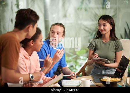 Group of high school students gathered at home to discuss ideas for project Stock Photo