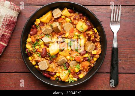 Vegan Cowboy Stew with onion, bell pepper, TVP granules,  crushed tomatoes, kidney beans, potatoes, corn and vegan hot dog pieces Stock Photo