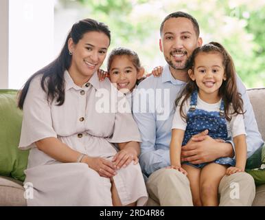 Happy, smile and family portrait on a sofa with love, embrace and bonding in their home together. Face, children and parents on a couch relax, sweet Stock Photo
