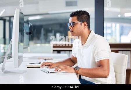 Computer, IT and man developer typing or coding in an office working on a project online, web or internet. Website, search and professional person or Stock Photo